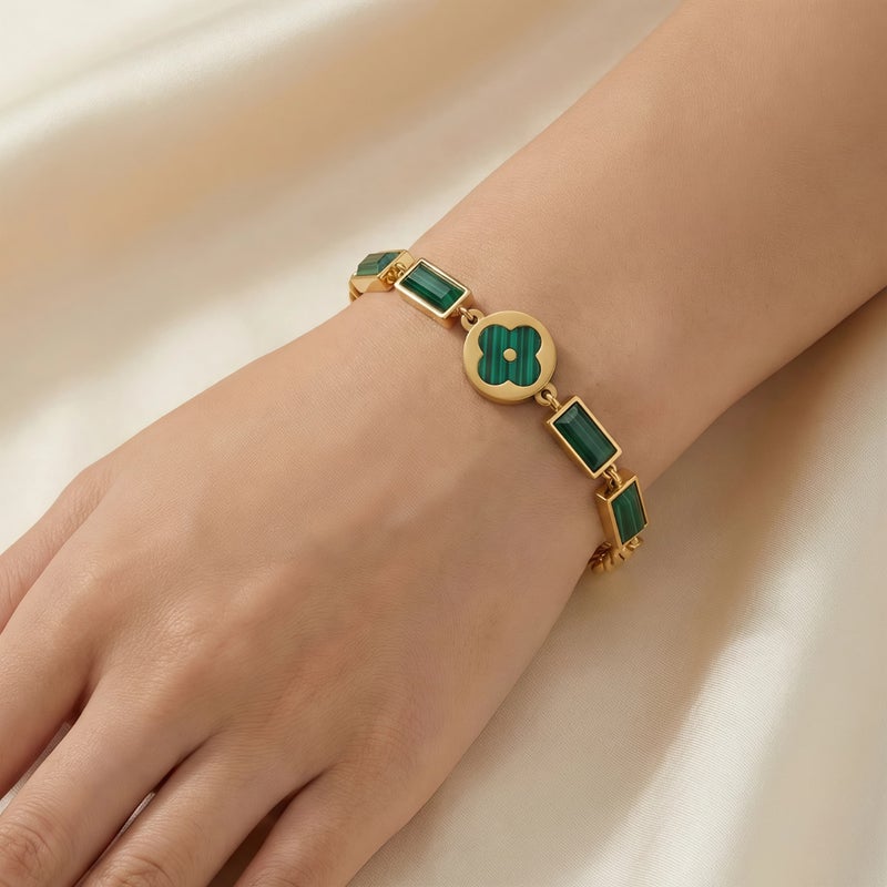 An elegant gold bracelet made of rust-resistant stainless steel, featuring a small, distinctive green flower at its center, adorned with green stones. It has an adjustable clasp for a perfect fit. - Image 3